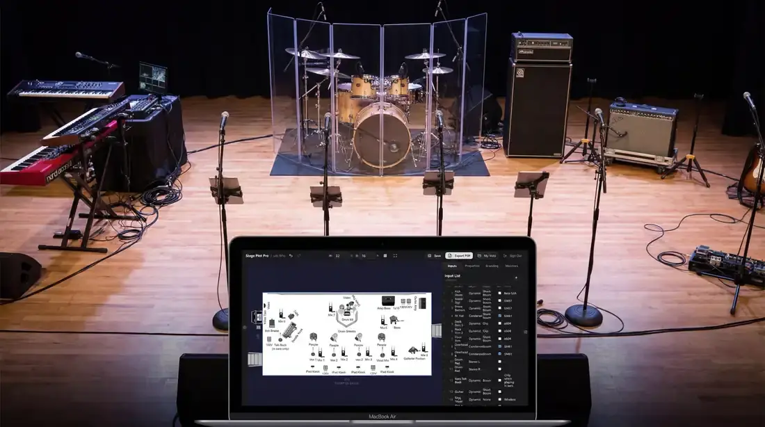 Live stage showing instruments, microphones, wedges, and cable paths